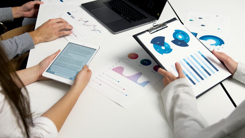 A team of financial analysts examining performance charts and reports on the Nippon India Mutual Fund.